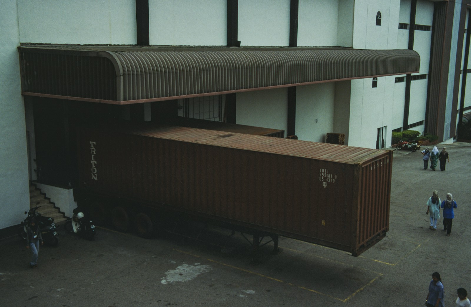 Truk kontainer bersandar di loading dock pabrik berkanopi